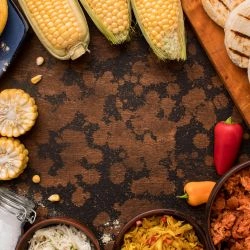 arranjo-de-comida-circular-de-vista-superior-com-milho-paes-e-temperos